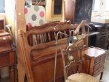 a room with a bed, a chair, a lamp, and a mirror