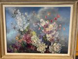 un tableau représentant des fleurs, dans un cadre doré, posé sur une table