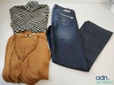 deux paires de jeans et un pull sont posés sur une table