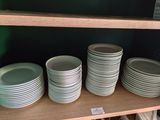 beaucoup d'assiettes sur une étagère dans la cuisine