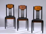 three black chairs with a brown seat and a black back