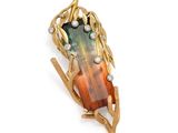 an image of a broochle with a green and orange stone