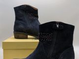 navy sued ankle boots with studs on the side and a yellow box