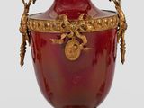 un grand vase rouge orné de motifs dorés