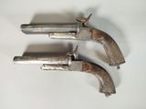 two old guns are sitting on a white surface