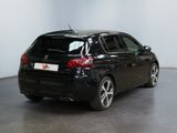 the back of a black car is parked in a large room