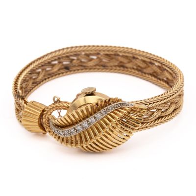 gros plan d'un bracelet en or et diamants sur fond blanc