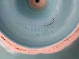 a close up of a blue vase with a hole in it