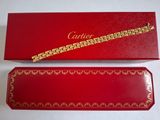 une boîte rouge sur laquelle est posé un bracelet en or