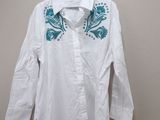 white shirt with blue flowers on it hanging on a hanger