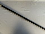 a black cane with a handle on a white cloth