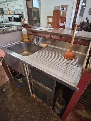 a man standing in a kitchen next to a sink