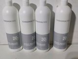 quatre bouteilles de shampoing alignées sur un plan de travail