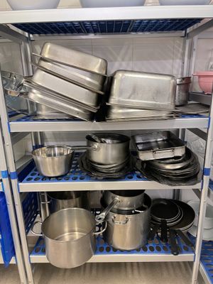 de nombreuses casseroles et poêles sur les étagères de la cuisine