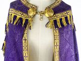 an image of a purple and gold cape with fringes on a mannequin