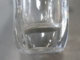a glass of water sitting on a table with a person in the background