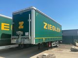 a green and yellow semi truck parked in a parking lot