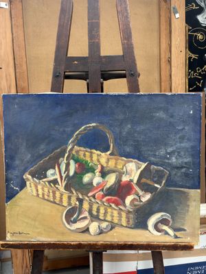 un tableau représentant un panier de fruits posé sur un chevalet
