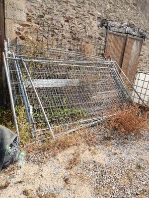 a man that is sitting on the ground next to a fence