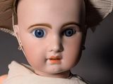 a close up of a doll with a hat on