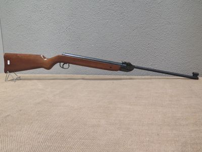 a rifle on a table next to a wall