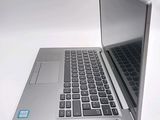 a silver laptop computer sitting on top of a white table