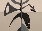 une sculpture métallique représentant un oiseau perché sur un poteau