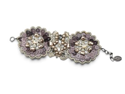 a close up of a bracelet with flowers and pearls on it