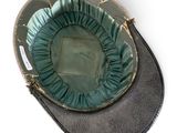 a black hat with a green ruffle on it