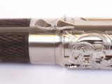 a silver and black pen on a white surface