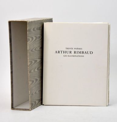 un livre ouvert posé sur une table blanche, à côté d'une boîte