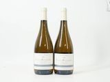 deux bouteilles de vin blanc posées sur une surface blanche