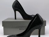 a close up of a pair of black high heels on a box