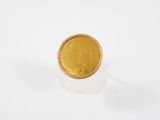 gros plan d'une pièce d'or sur une surface blanche