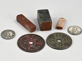 plusieurs types de pièces de monnaie et un bloc en bois posés sur une surface blanche