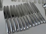 a lot of silver spoons and knives on the table