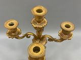 an antique brass candelabra with three candles on a stand