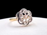un gros plan d'une bague en or ornée de perles sur un fond blanc