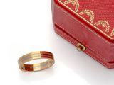 une boîte rouge et une bague en or sur un fond blanc