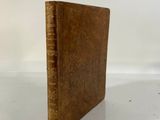 an old book sitting on top of a table next to a white wall