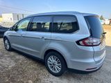 the rear end of a silver van parked in a parking lot