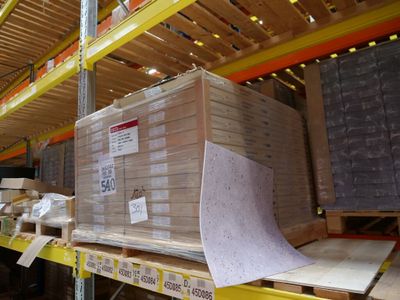 un grand carton posé sur une palette dans un entrepôt