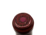 a close up of a bottle of wine on a white surface