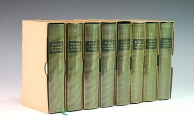 six livres verts sont alignés sur une surface blanche
