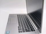 a silver laptop computer sitting on top of a white table
