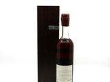 a bottle of whisky sitting next to a box on a white surface