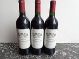 trois bouteilles de vin posées sur une table l'une à côté de l'autre