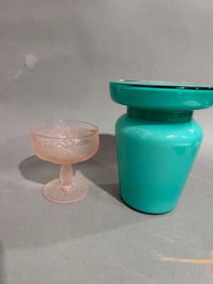 a blue vase and a glass sitting on a table