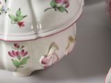 a white bowl with pink flowers on it sitting on a table