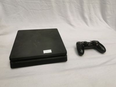 une console de jeux vidéo et une manette posées sur un drap blanc